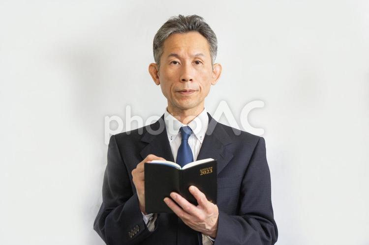 メモをとる背広姿の中高年ビジネスマン サラリーマン,ビジネスマン,社長の写真素材