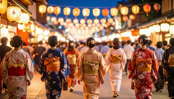 夏祭りの中を歩く浴衣姿の女性たち 夏祭りの中を歩く浴衣姿の女性たちの写真