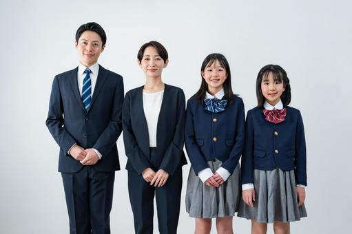 スーツを着た男女と制服を着た女の子二人 入学式,父母,母親の写真素材