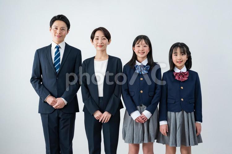 スーツを着た男女と制服を着た女の子二人 入学式,父母,母親の写真素材