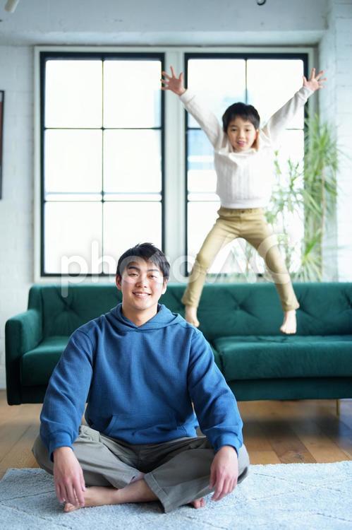 あぐらの男性とジャンプの男の子 親子,男の子,小学生の写真素材