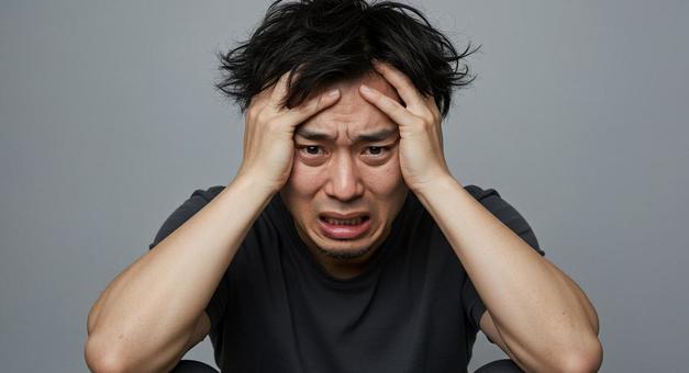 頭を抱えている男性 頭を抱えている男性の写真