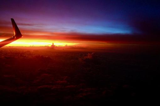 飛行機の窓から眺める夕焼け空 飛行機の窓から眺める夕焼け空の写真