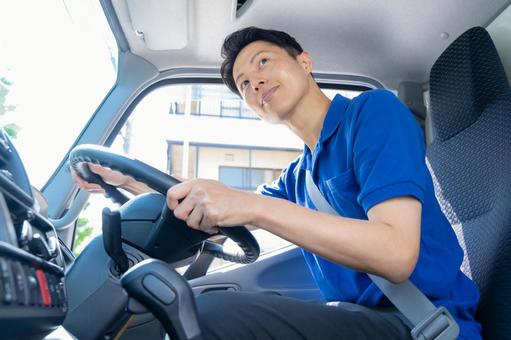 トラックを運転する男性ドライバー トラックを運転する男性ドライバー ドライバー,トラック,運転手の写真素材