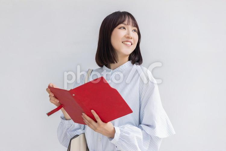 手帳を持つ笑顔のビジネスウーマン 女性,ビジネス,ビジネスウーマンの写真素材