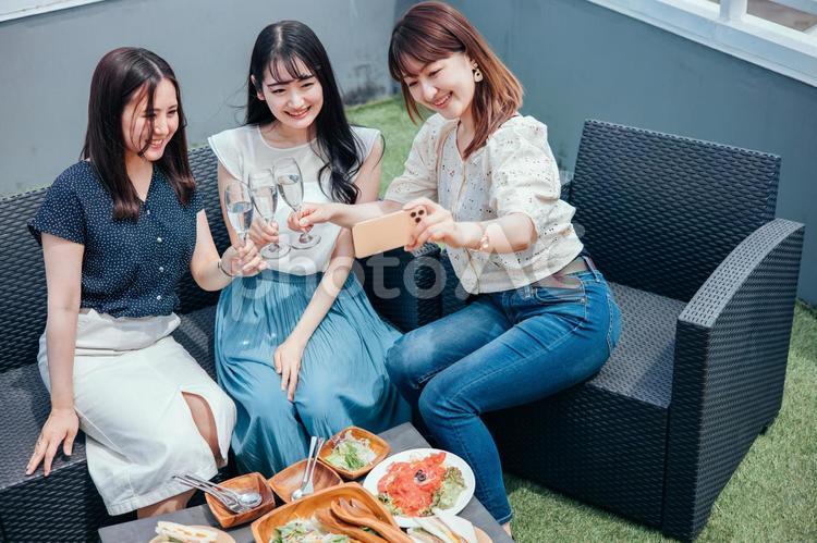 屋上でパーティーをする女性たち（自撮り） 女子会,自撮り,スマホの写真素材