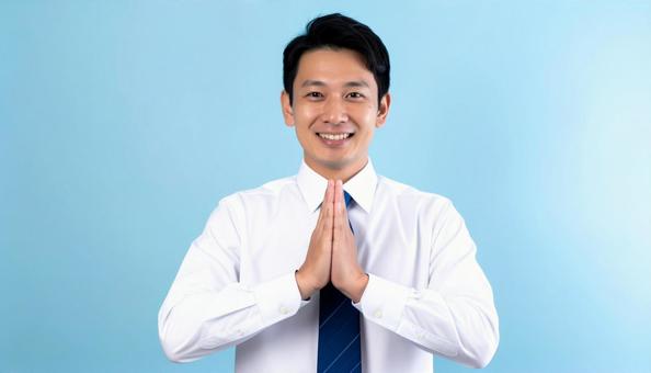 両手をあわせてお願いしているビジネスマン 両手をあわせてお願いしているビジネスマンの写真