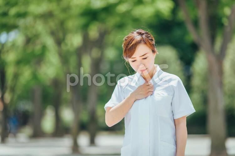 体調不良の白衣の女性 看護師,ナース,咳の写真素材