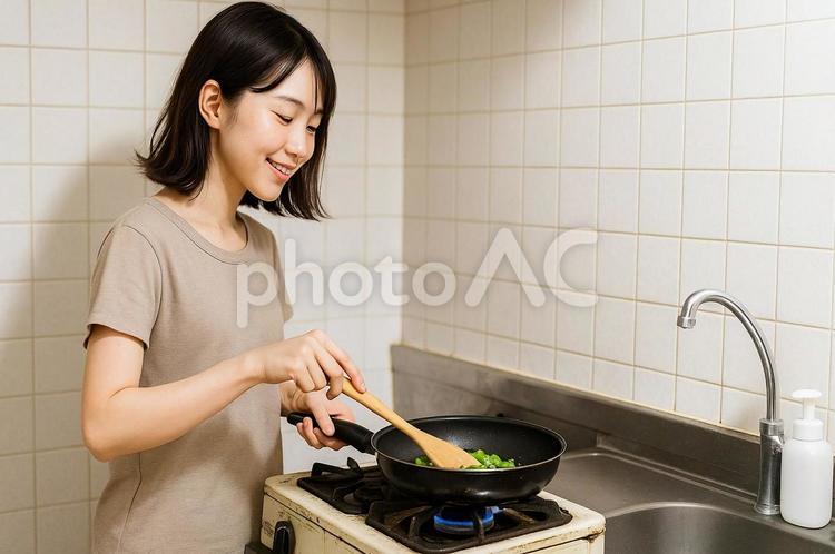 ガスコンロで調理している一人暮らしの女性 ガスコンロ,調理,一人暮らしの写真素材