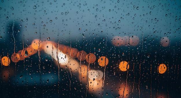 雨に濡れる窓越しにぼやける街の光 雨に濡れる窓越しにぼやける街の光の写真