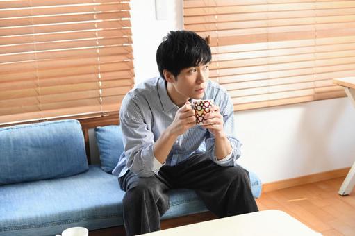 Relaxing young Asian man drinking a drink indoors, JPG Relaxing young Asian man drinking a drink indoors, lifestyle, male, sit, JPG