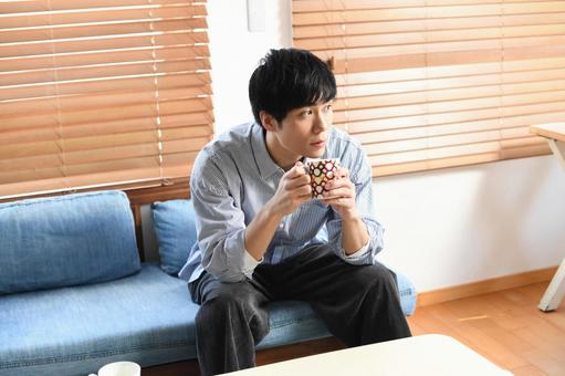 Relaxing young Asian man drinking a drink indoors, phong cách sống, người, ngồi, JPG