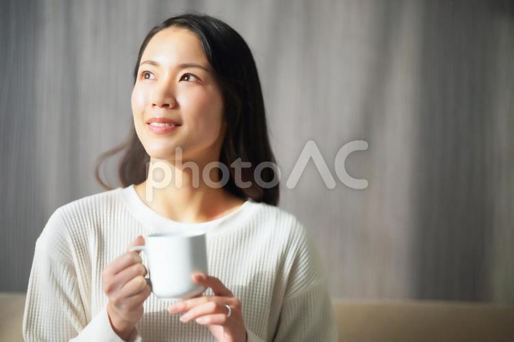 ソファーでコーヒーを飲むパジャマ姿の女性4 パジャマ,女性,日本人の写真素材