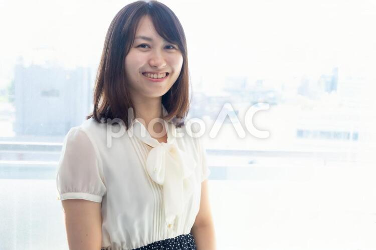 窓際に立つ笑顔の女性 窓際に立つ笑顔の女性 女性,笑顔,笑うの写真素材