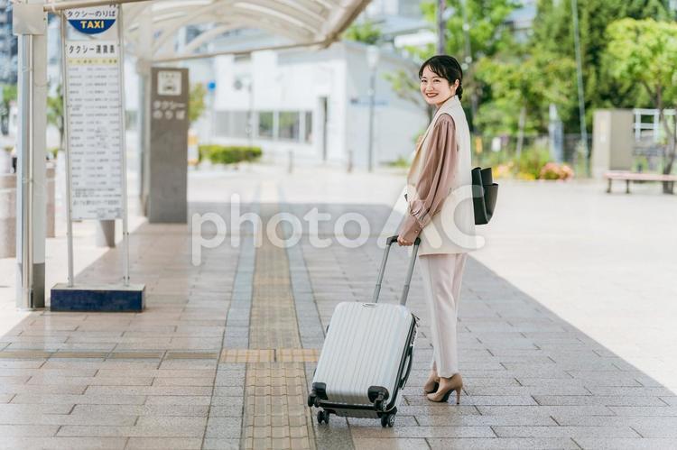 駅のタクシー乗り場を歩くビジネスウーマン 出張,新生活,転勤の写真素材