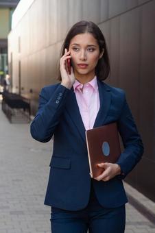 街なかを電話しながら歩いているビジネスウーマン ビジネスウーマン,ビジネス,女性の写真素材