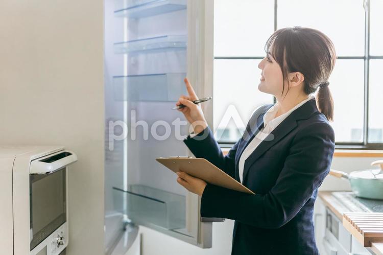 冷蔵庫を点検するビジネスウーマン 冷蔵庫,家電,点検の写真素材