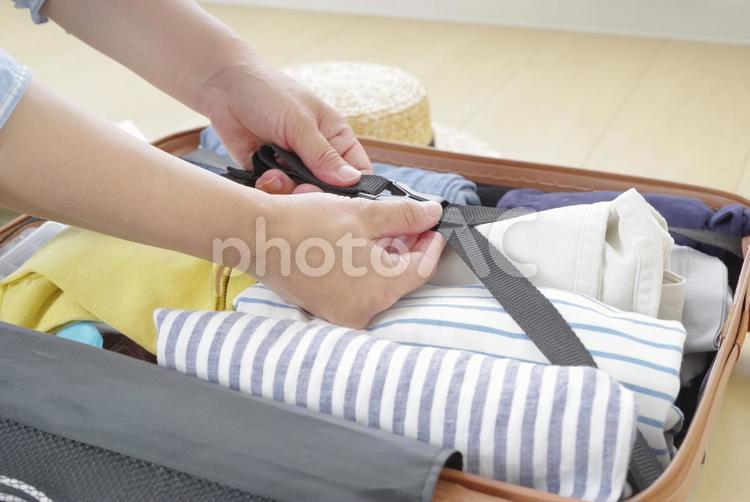旅行の支度をするシニア女性の手元 トランク,スーツケース,荷造りの写真素材