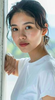 白いTシャツの女性が壁際でポーズをとる 白いTシャツの女性が壁際でポーズをとるの写真