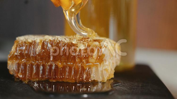 蜜蝋に蜂蜜をかける様子 蜜蝋,天然素材,保湿の写真素材