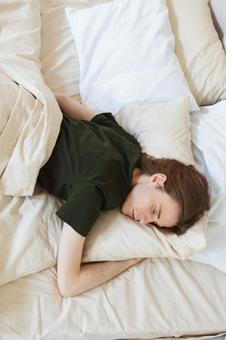 ベッドでうつ伏せで寝ている若い男性 男性,外国人,欧米人の写真素材