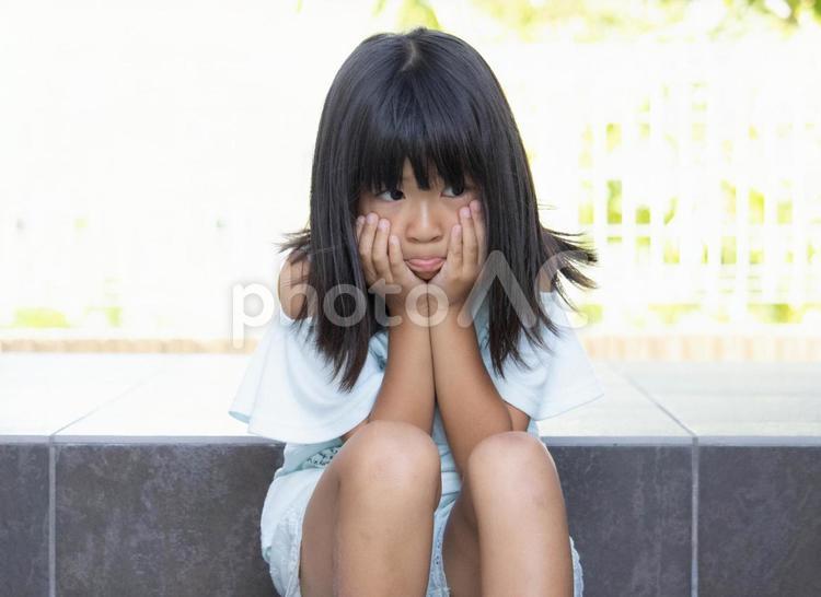 しょんぼり座り込む子供 悲しい,涙,いじめの写真素材