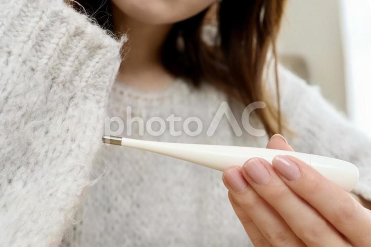 体温計を確認する女性 体温計,検温,発熱の写真素材