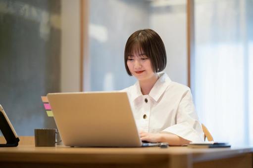 A young woman operating a laptop in her room, الطبقة على الانترنت, امرأة, العمل عن بعد, JPG