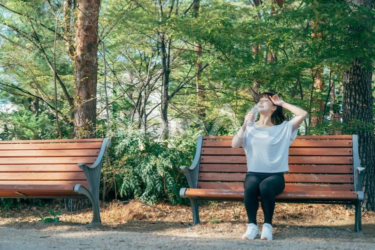 トレーニング中に休憩する女性（水を飲む・笑顔） 水分補給,汗,水の写真素材