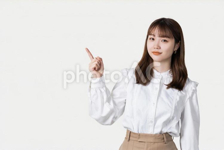 人差し指を立てて案内するビジネスウーマン 女性,ビジネス,笑顔の写真素材