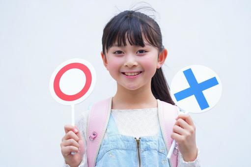 マルバツの札を持つランドセルを背負った女の子（白背景） 子ども,女の子,小学生の写真素材