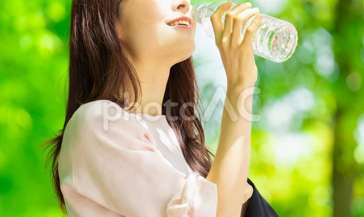 ペットボトルの水を飲む女性・熱中症対策 女性,水分,水の写真素材