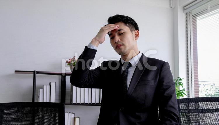 手を額に当てて苦悩するサラリーマン 苦悩,ストレス,心配の写真素材