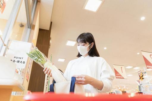 スーパーで買い物袋に商品を詰める女性 スーパーで買い物袋に商品を詰める女性 スーパー,女性,日本人の写真素材