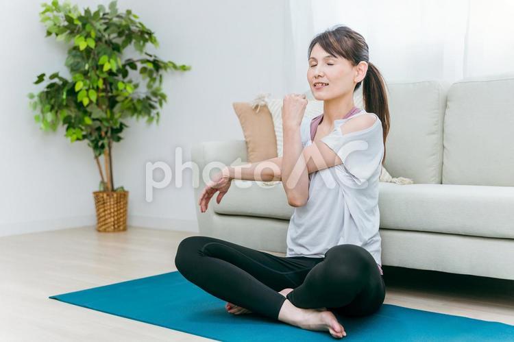 部屋でヨガをするミドル世代の女性 ヨガ,ピラティス,筋トレの写真素材