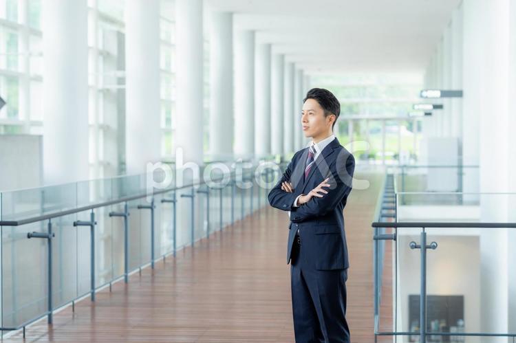 オフィスの廊下に立つビジネスマン ビジネスマン,スーツ,オフィスの写真素材