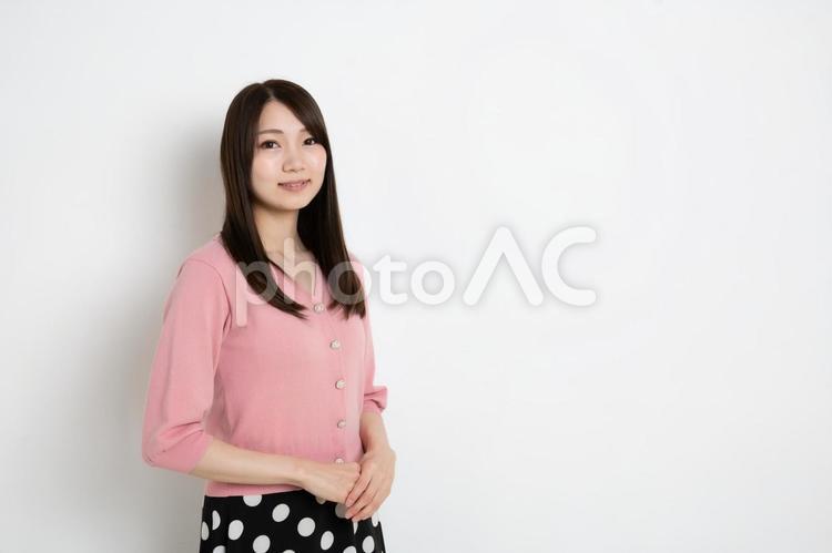 両手を前に組み笑っている若い女性（コピースペース） 女性,日本人,女の写真素材