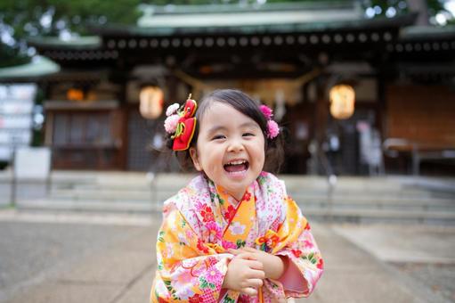 神社の前で笑顔を見せる着物姿の女の子 神社の前で笑顔を見せる着物姿の女の子の写真