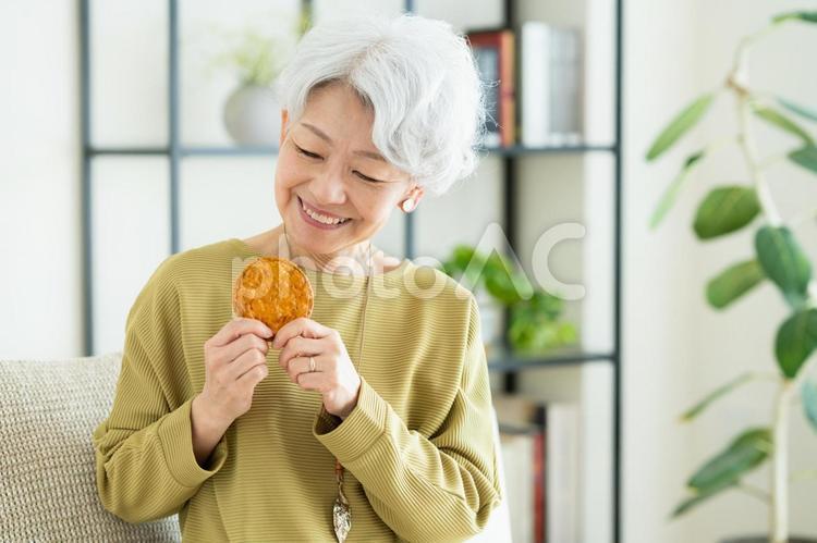 せんべいを食べるシニアの女性 せんべい,煎餅,歯の写真素材