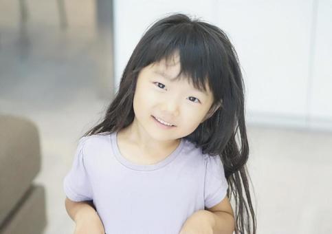首をかしげた笑顔の女の子 首をかしげた笑顔の女の子の写真