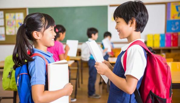 授業でペアになって英会話の練習をする子供の写真