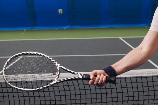 テニスラケットとリストバンドの手元の写真