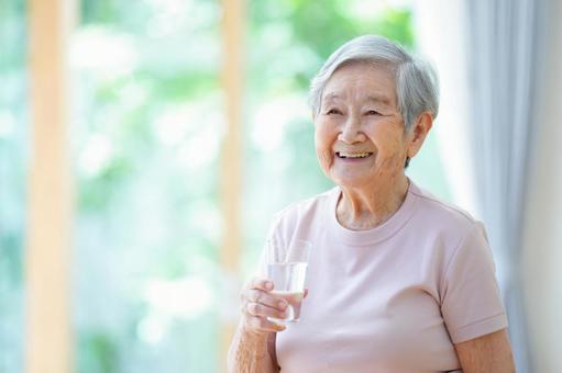 コップを持ち笑う半袖のおばあちゃん 女性,コップ,水の写真素材