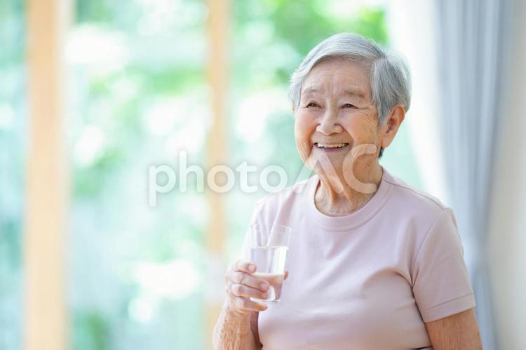 コップを持ち笑う半袖のおばあちゃん 女性,コップ,水の写真素材