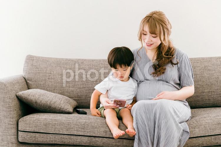 子供とスマホを見る妊娠中の日本人女性 親子,スマホ,子供の写真素材