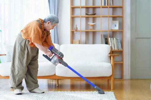 ラグを掃除する横向きの高齢女性 女性,掃除,掃除機の写真素材