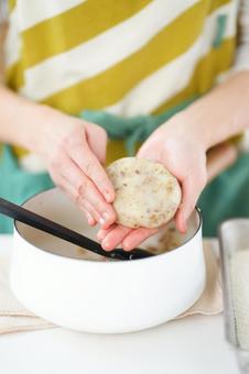 コロッケを成形している手の写真