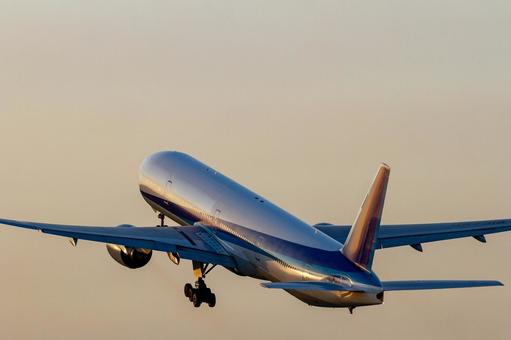 夕暮れの空へ離陸する旅客機 飛行機,空港,離陸の写真素材