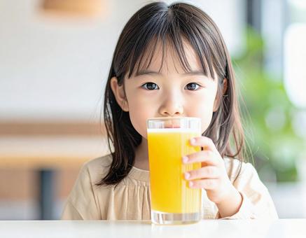 オレンジジュースを飲む子供 オレンジジュースを飲む子供の写真