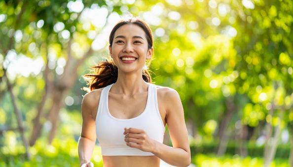 笑顔でジョギングする若い女性 笑顔でジョギングする若い女性の写真